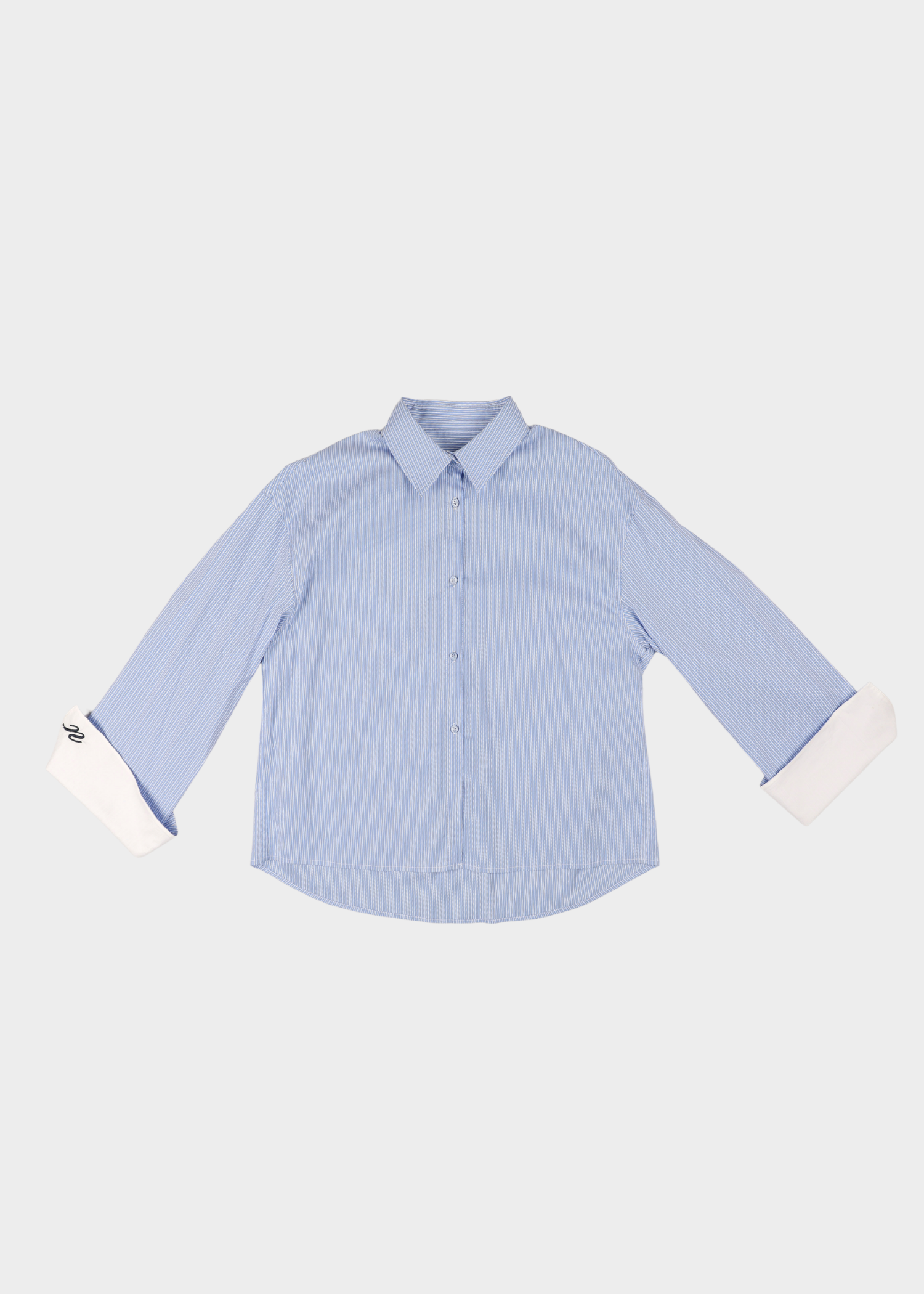 Noted Antwerp blue striped Anni shirt. A light blue and white vertically striped long-sleeve button-down shirt with white turned-up cuffs, displayed flat against a light gray background.