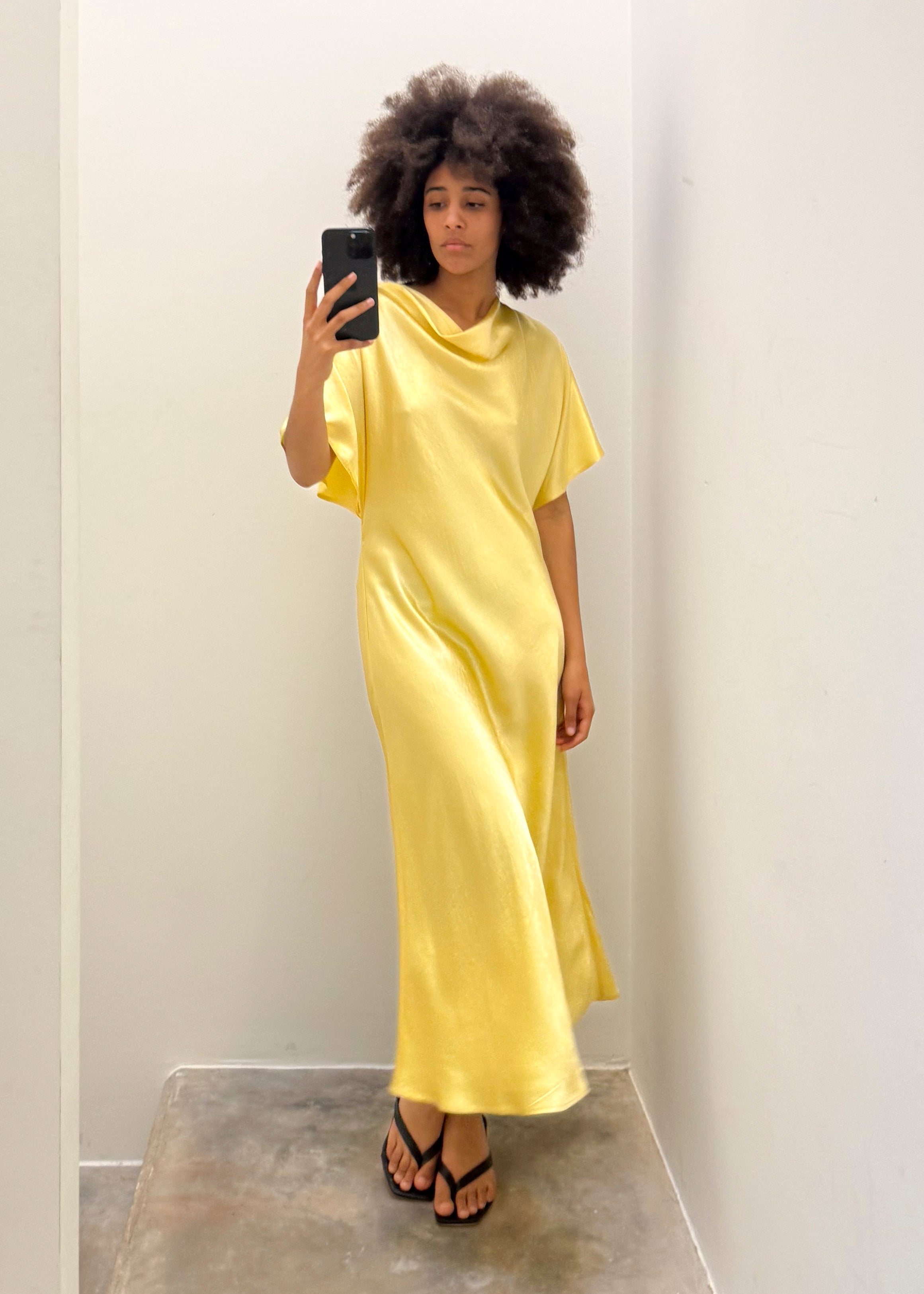 Long satin yellow dress with flairy shape by Noted Antwerp.