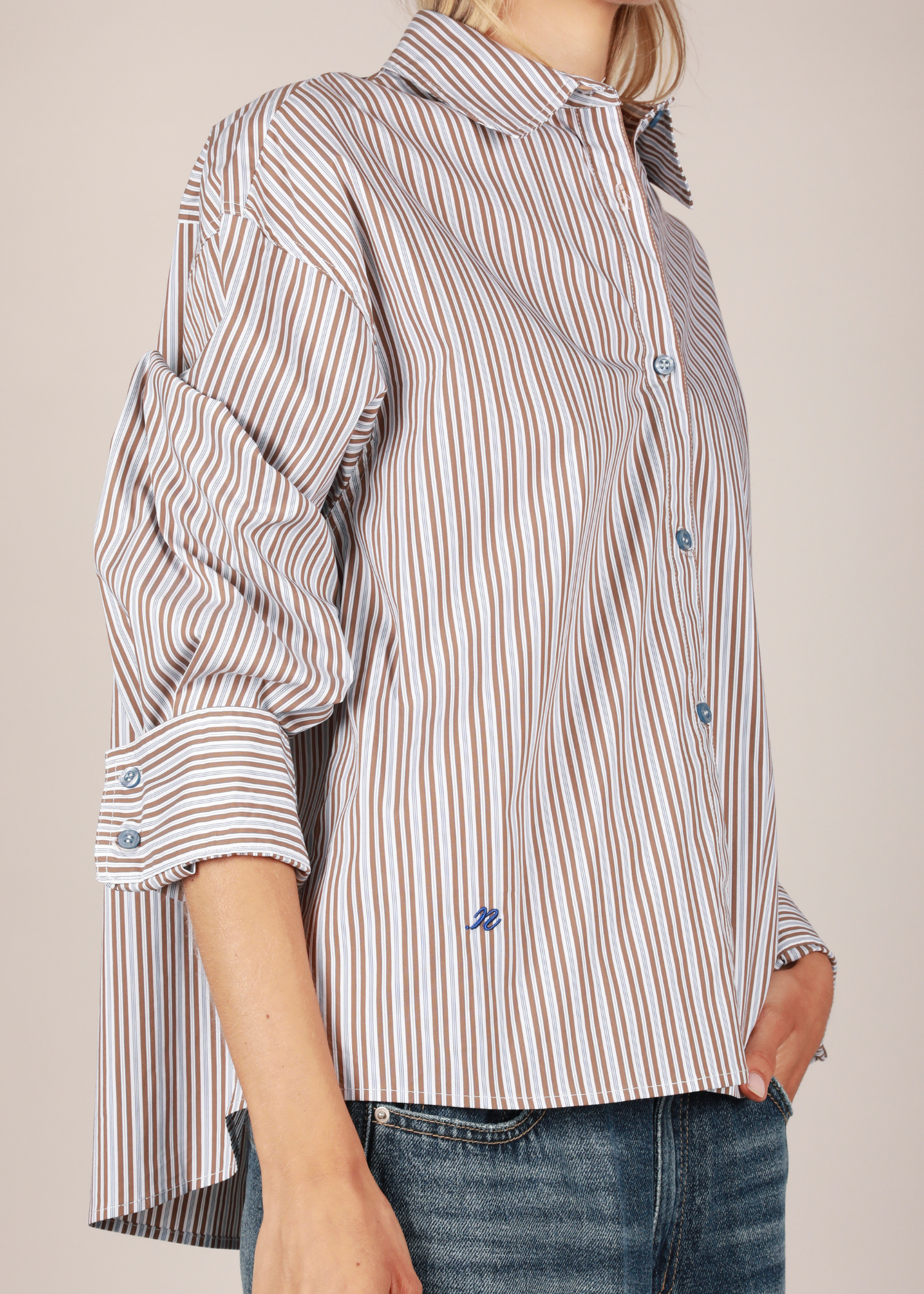 Detail of the NOTED ANTWERP Anni shirt in blue brown striped pattern.