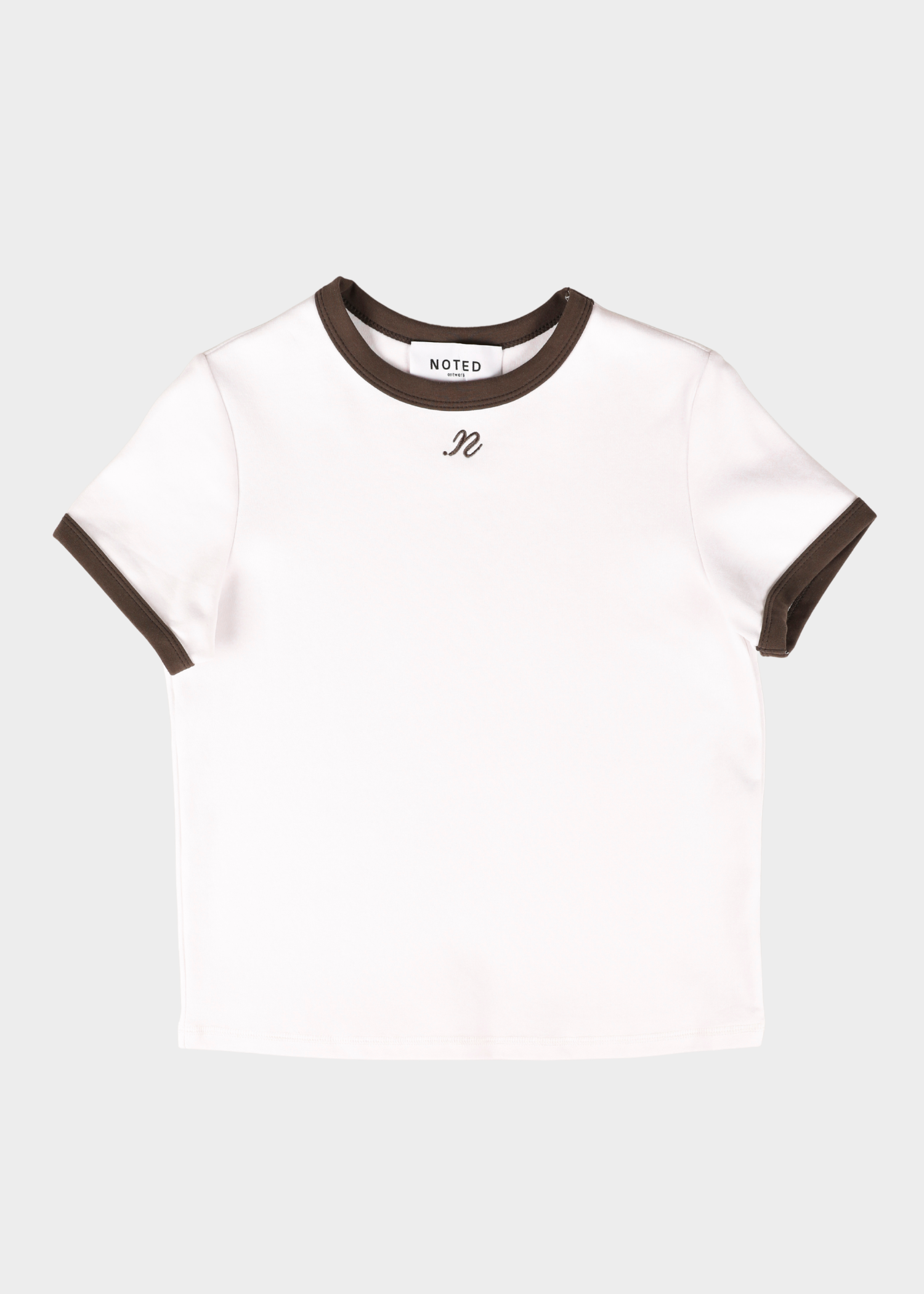 A white short-sleeve ringer T-shirt with dark brown ribbed trim at the crew neck and sleeve cuffs, featuring a small black embroidered script logo on the chest. The brand name 'NOTED' is visible on the inner neck label.