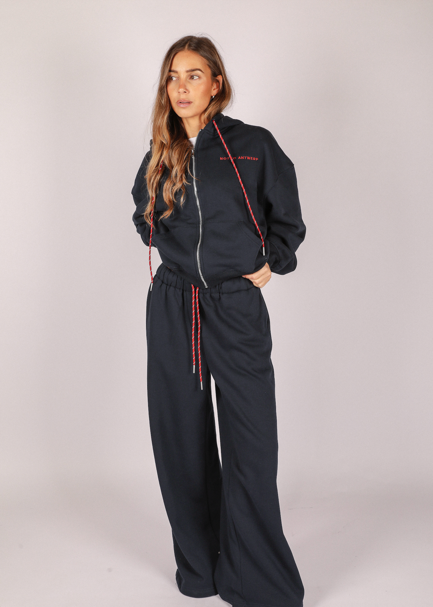 Woman wearing a blue tracksuit with red accents