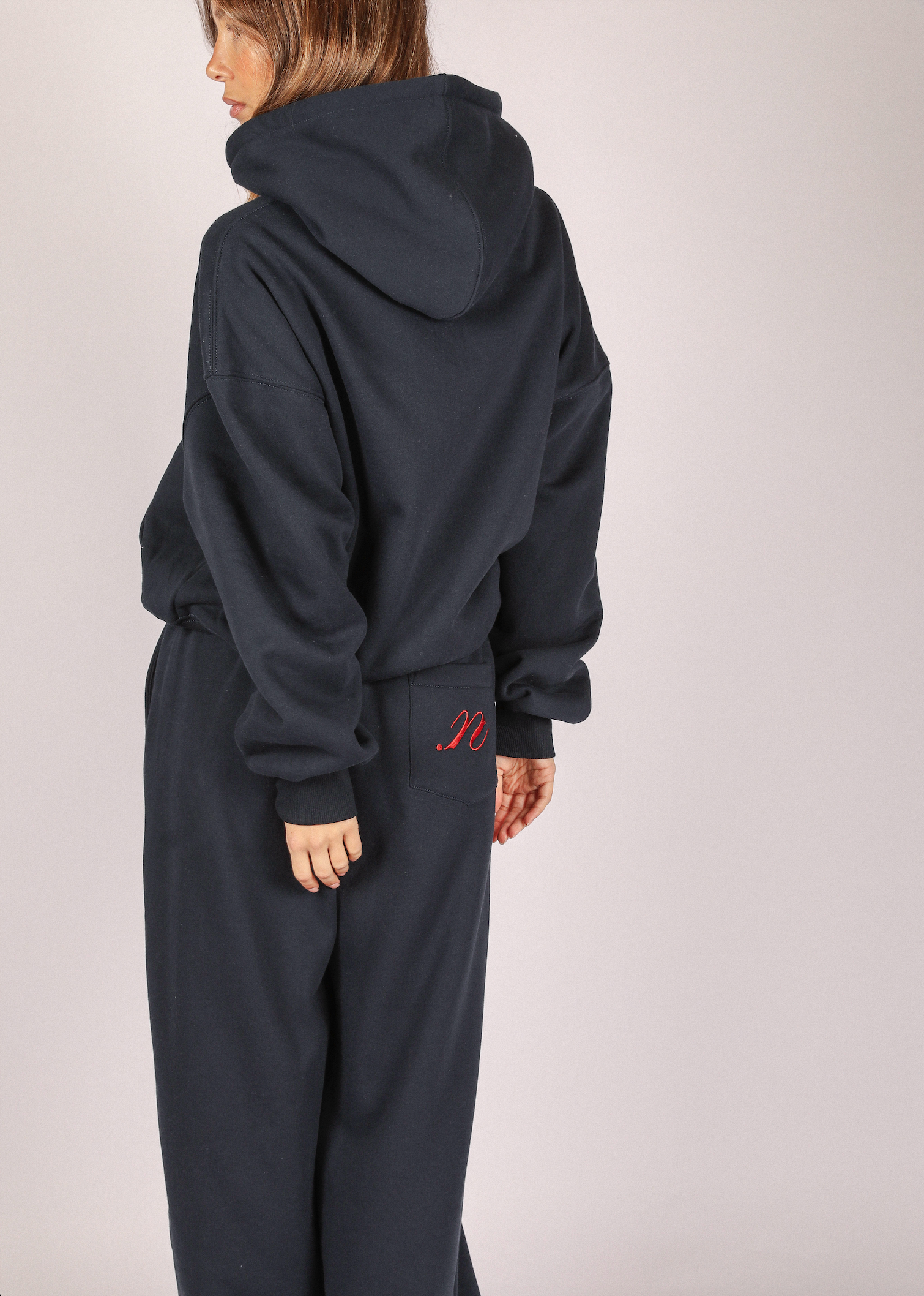 Person wearing a navy hoodie and pants with noted antwerp hoodie