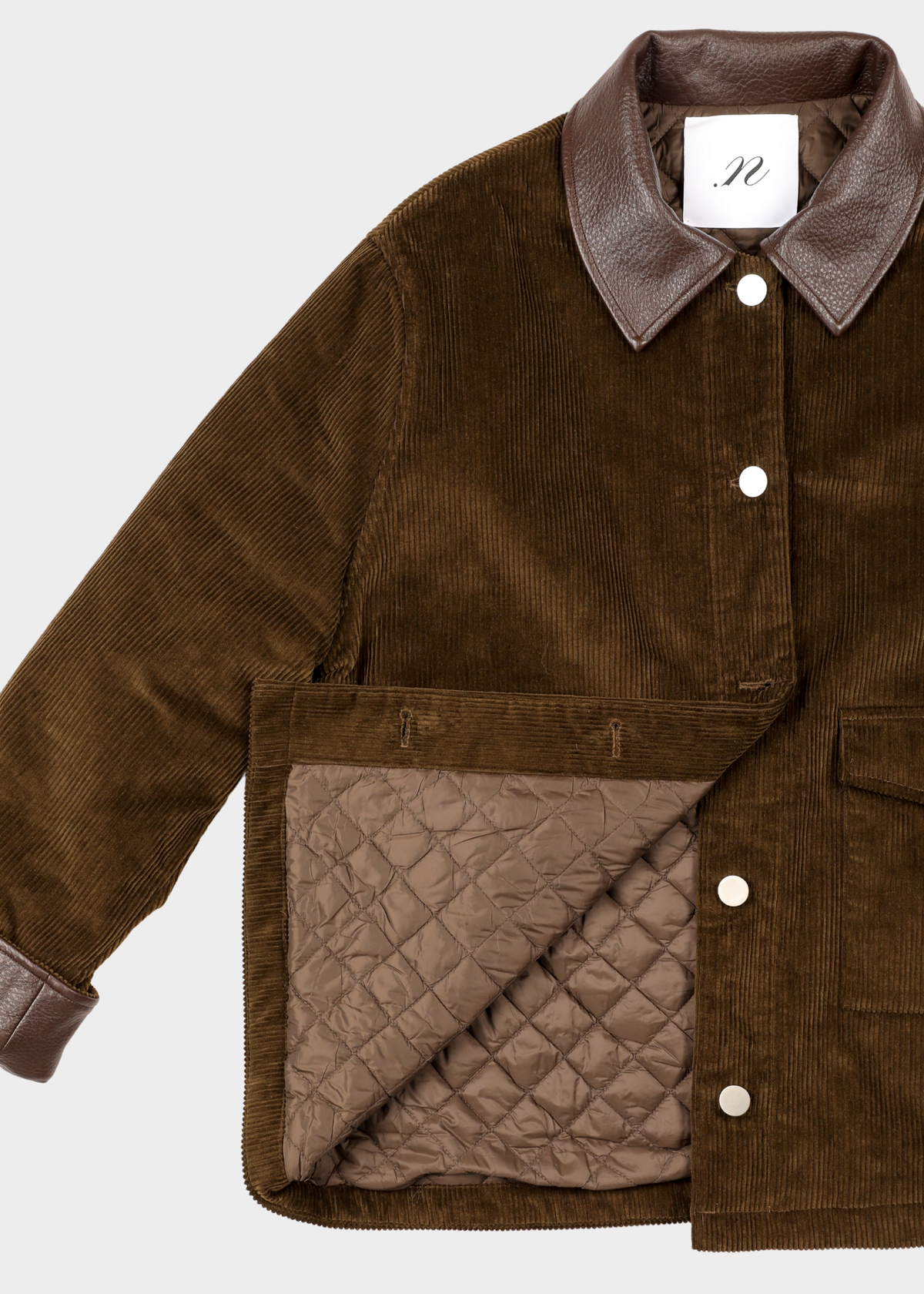 A brown corduroy jacket with dark brown leather-like collar and cuff trim, featuring a quilted brown lining shown at the front pocket, photographed on a light gray background.