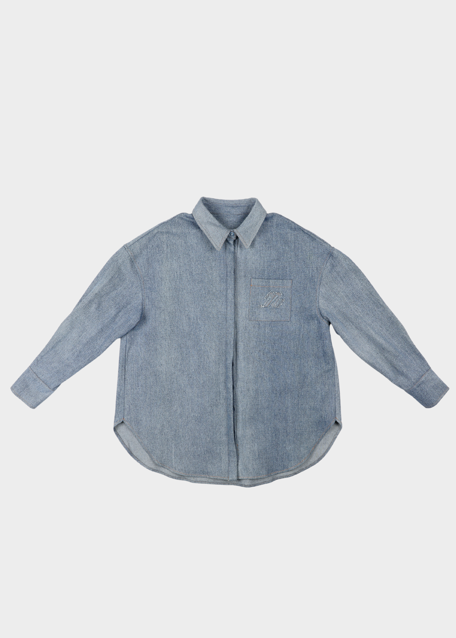 Noted Antwerp celi shirt light blue denim long-sleeve button-up shirt with a single chest pocket, laid flat against a light gray background.