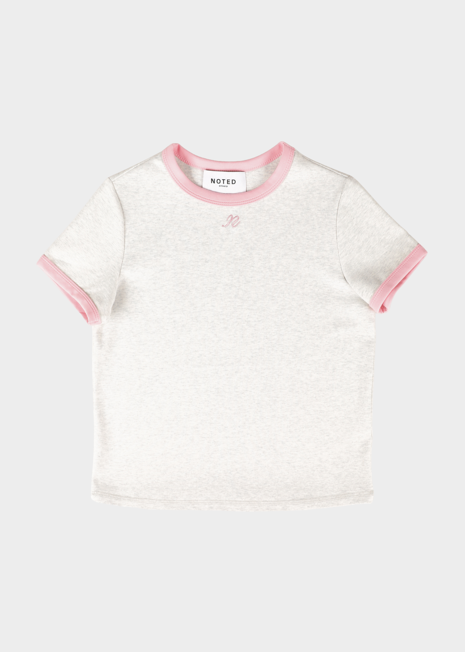 A white short-sleeve t-shirt with pink ribbed trim on the crew neck and sleeve cuffs, featuring a small embroidered logo on the chest. The brand label 'NOTED' is visible inside the collar.