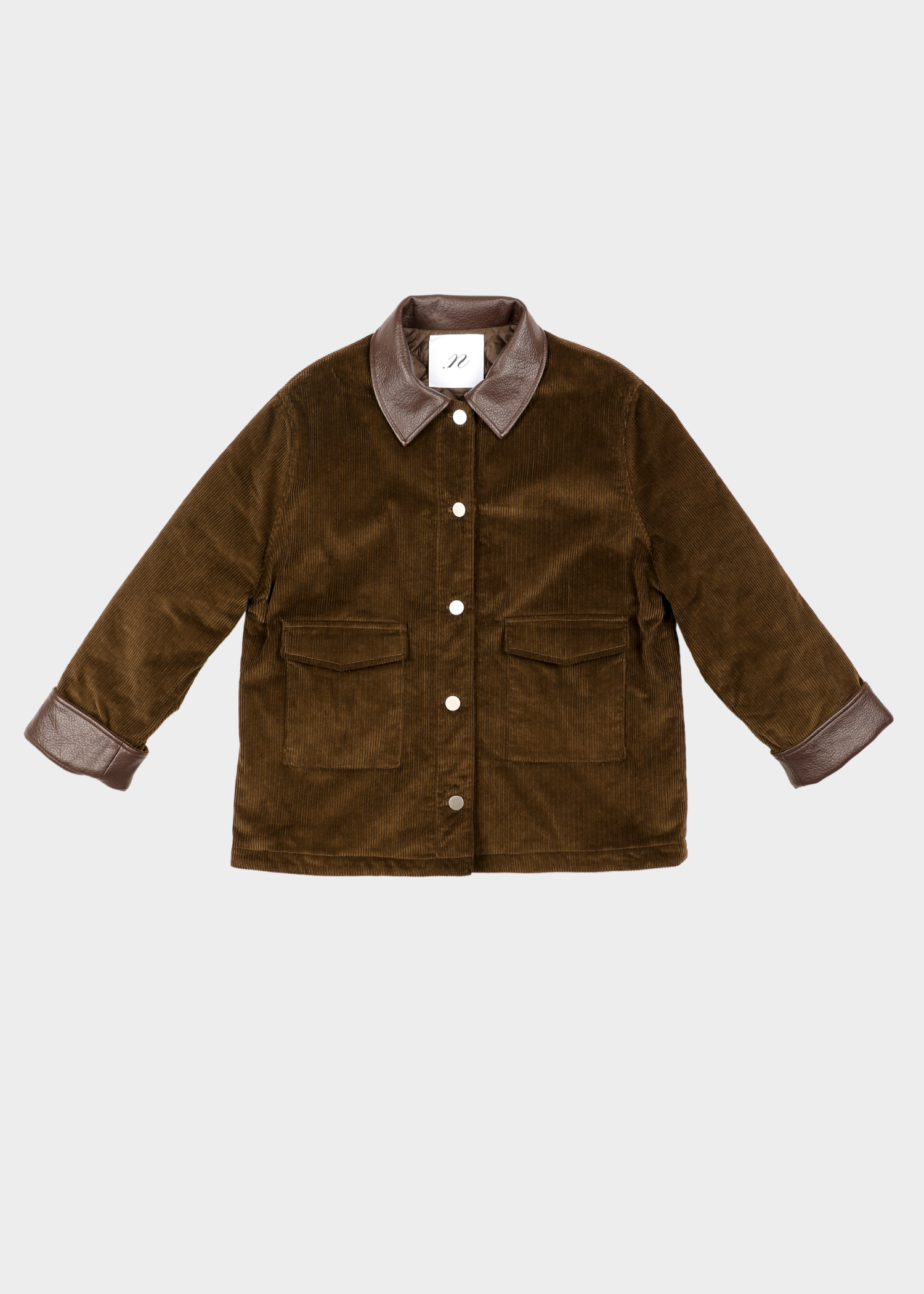 NOTED ANTWERP Boris coat - khaki leather. A brown corduroy jacket with a contrasting dark brown collar and cuffs, featuring a button-up front and two front flap pockets, shown flat on a light gray background. Our Boris coat in khaki is a fall winter staple. Featuring a brown leather collar and double patched pockets.