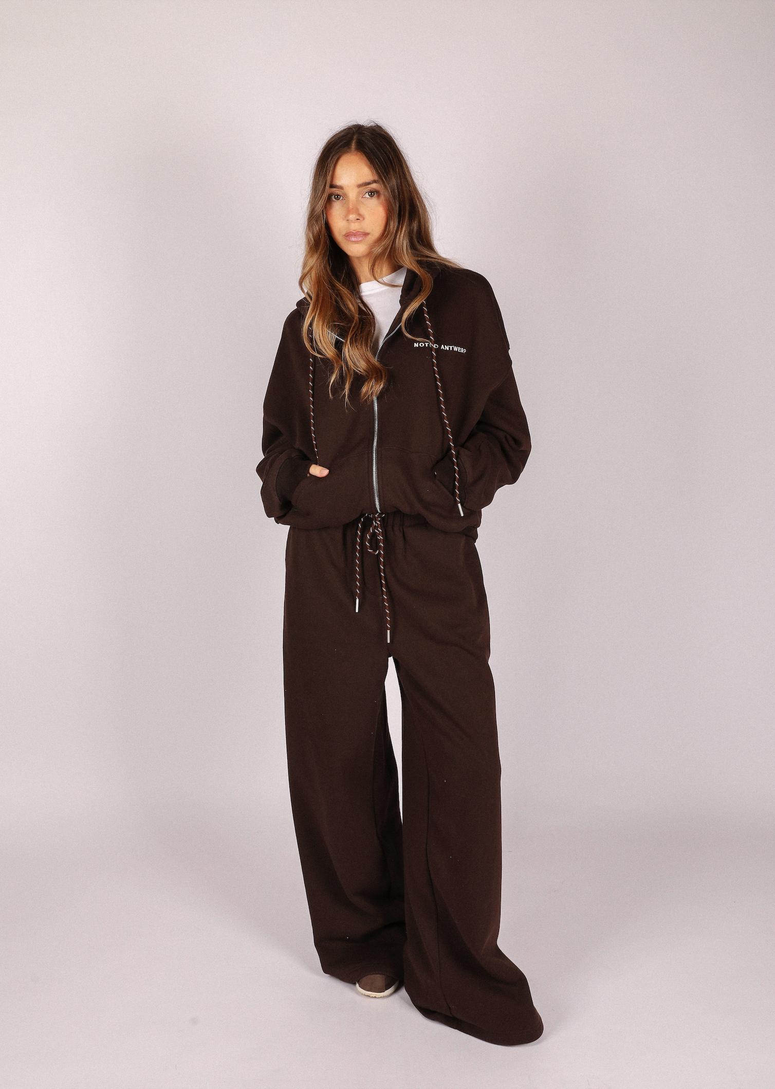 Woman wearing a brown tracksuit on a white background