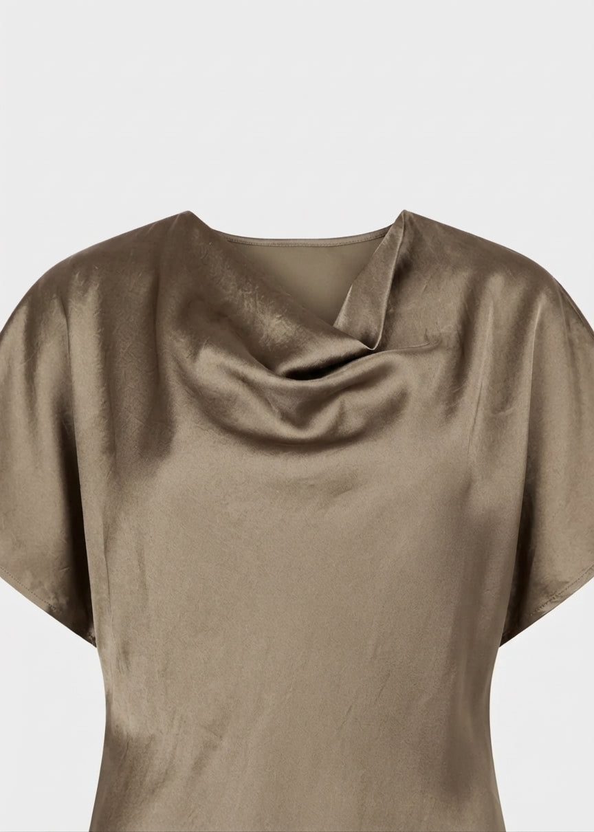 A close-up of a draped, short-sleeved top in a muted taupe-brown color, showing its soft satin-like texture and cowl neckline against a light gray background.
