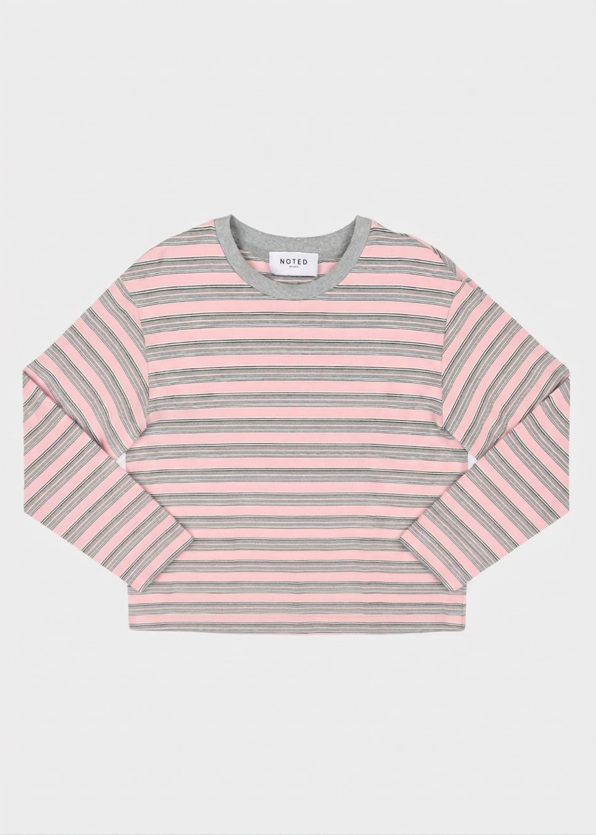 A woman long-sleeve striped top with horizontal pink, gray, and white stripes, featuring a solid gray crew neck, photographed flat against a light gray background. noted Antwerp